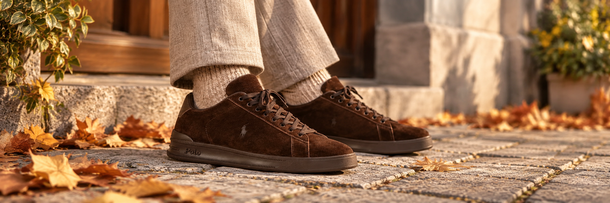 Mørkebrune Ralph Lauren-sneakers i semsket skinn på brostein med høstløv